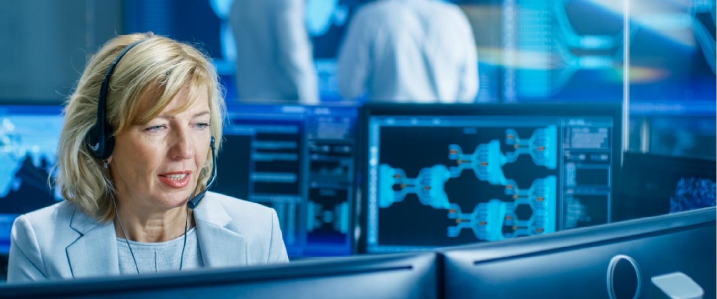 A woman on a computer working in a control centre.